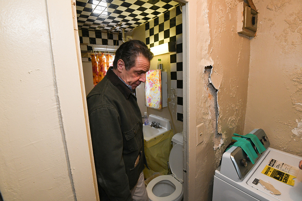 Andrew Cuomo looking at a washing machine