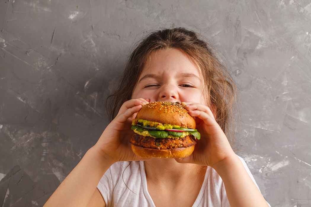Little girl eating a veggie burger